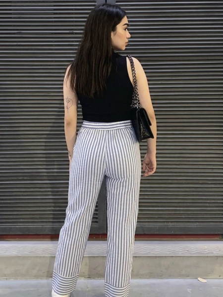 Close-up of folded hem detail in striped cotton pants
