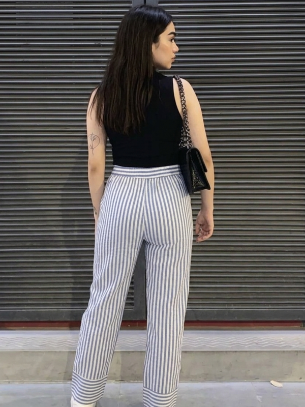 Close-up of folded hem detail in striped cotton pants